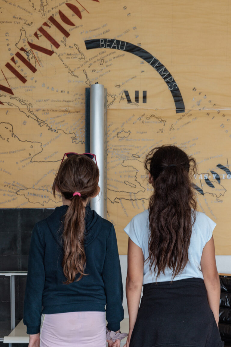 Jeunes filles devant une carte du monde lors de la visite de la Villa E-1027