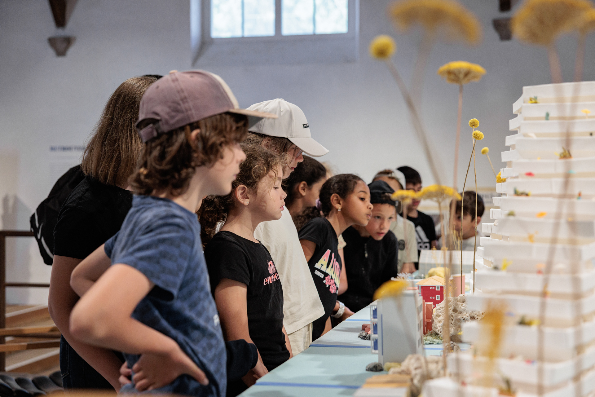 Groupe d'enfants devant des maquettes miniature d'une ville méditerranéenne