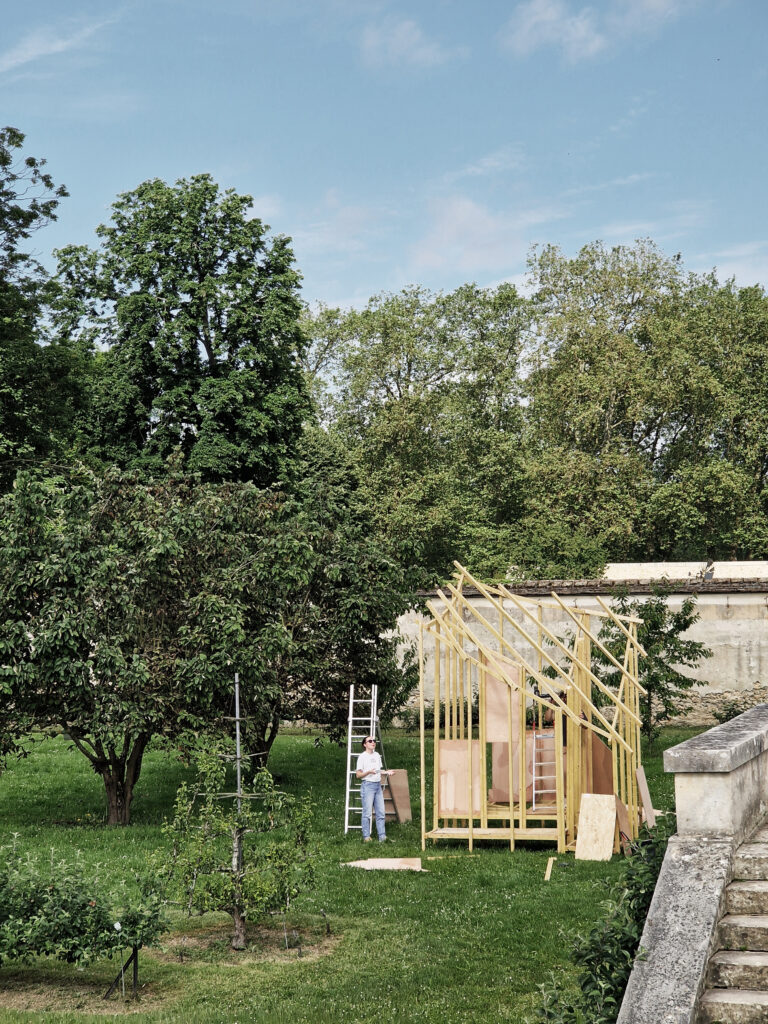 Structure en bois regardé par une femme dans un jardin à Versailles
