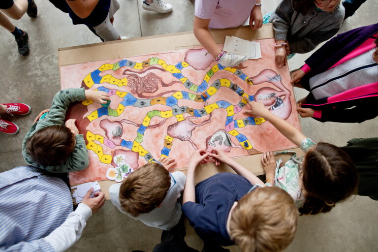 Un groupe de jeunes enfants, vue de haut, en train de jouer à un jeu de société