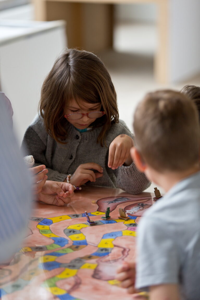 Une jeune fille plaçant ses pions sur un plateau de jeu de société.