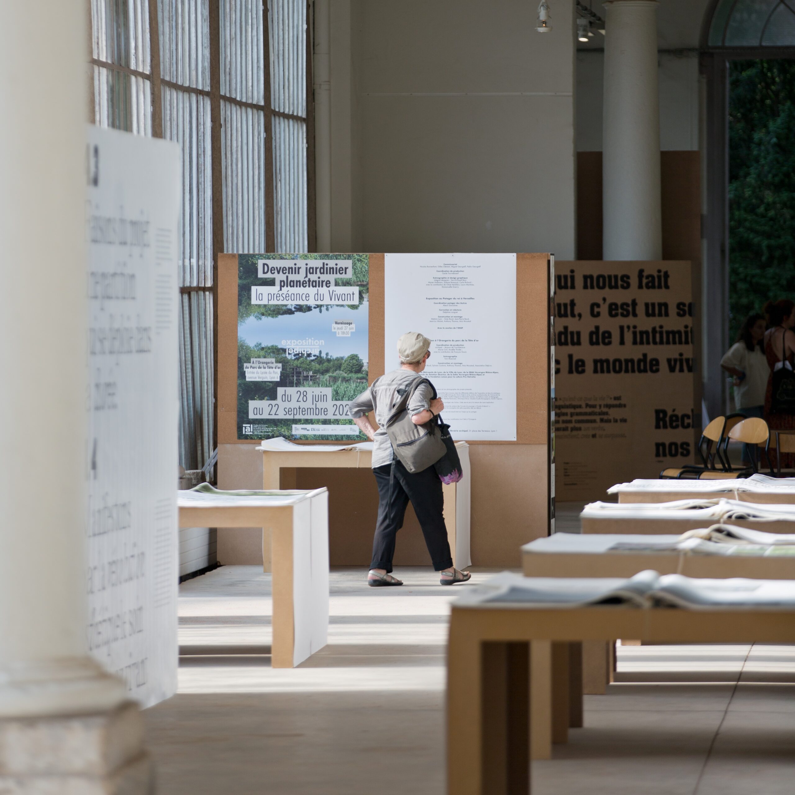 Femme en train de lire un texte sur un panneau en bois dans un musée à Lyon