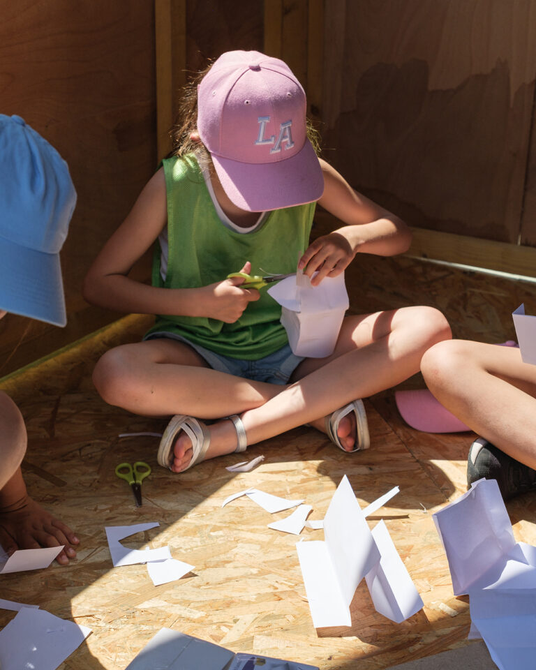 Jeune fille en train de faire une structure en papier.