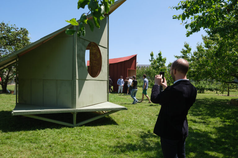 Homme en train de prendre en photo un structure en bois dans un jardin à Versailles